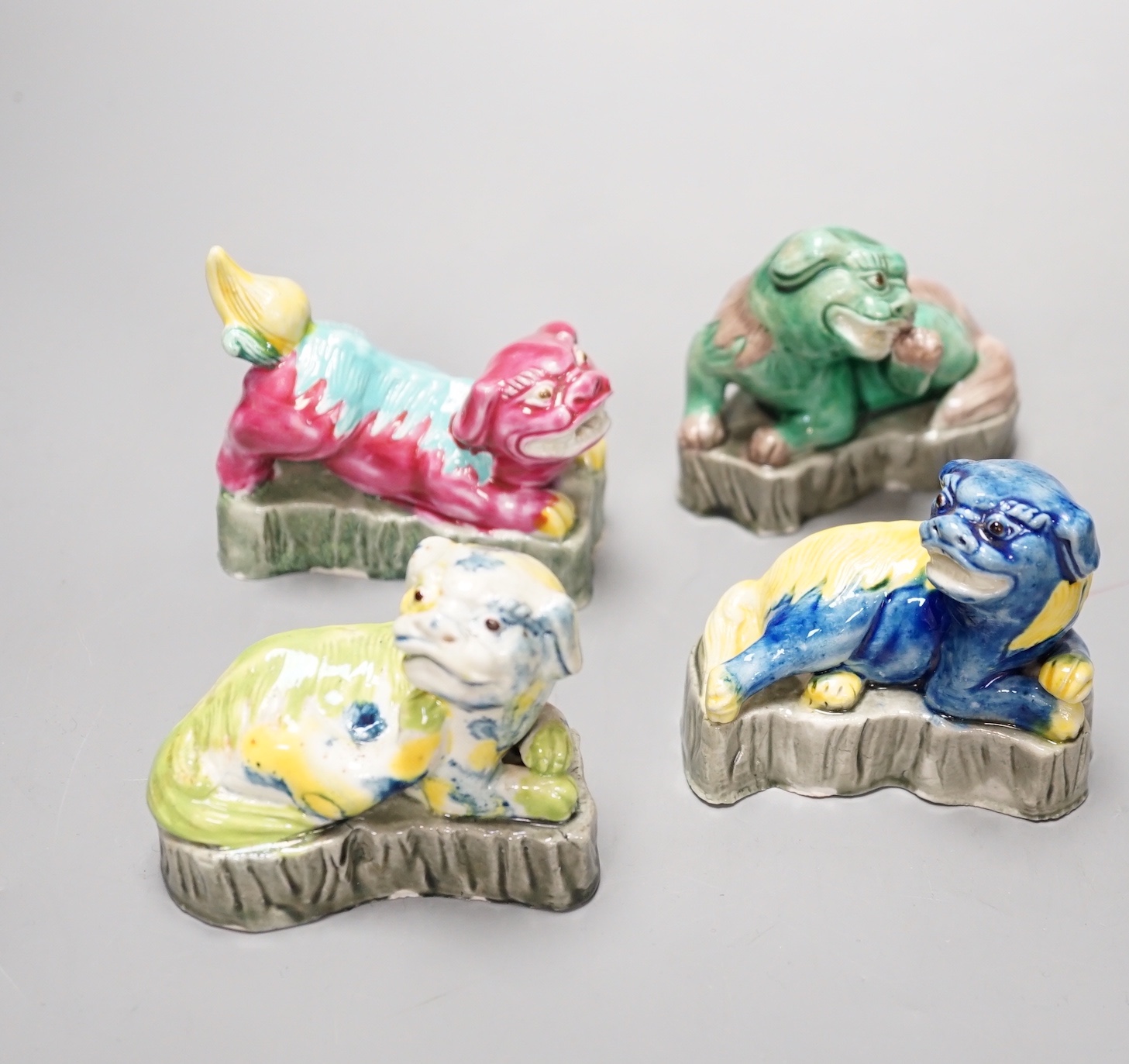 Four Chinese polychrome glazed models of lion-dogs, Republic period and a Chinese famille rose dish, Tongzhi mark, 15.5cm (5)